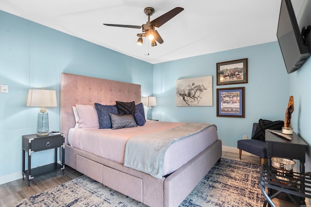 bedroom with dark wood-style floors, ceiling fan, and baseboards