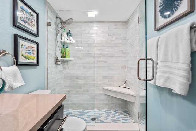 full bath with a stall shower, vanity, and toilet