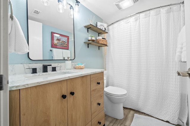 full bathroom featuring toilet, visible vents, wood finished floors, and vanity