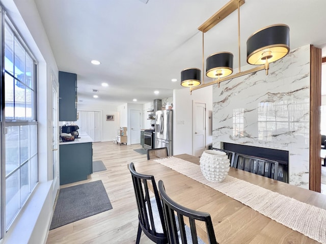 dining space featuring light wood finished floors and recessed lighting