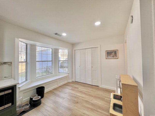 interior space with light wood-style flooring, visible vents, baseboards, and recessed lighting