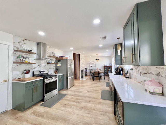 kitchen featuring light countertops, appliances with stainless steel finishes, open shelves, island exhaust hood, and pendant lighting