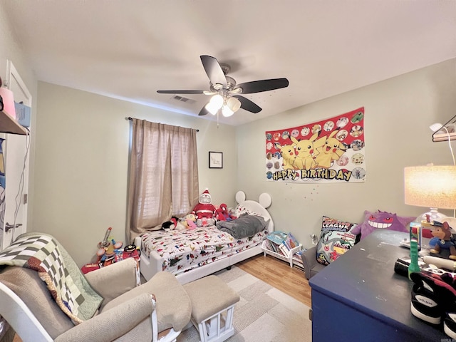 bedroom featuring visible vents, ceiling fan, and wood finished floors