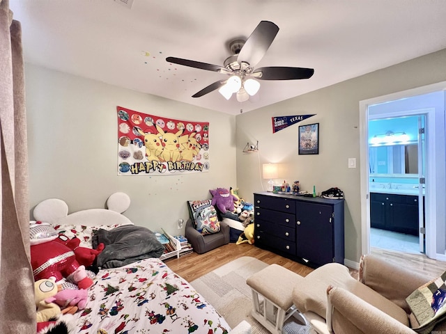 bedroom with ceiling fan, ensuite bath, a sink, and wood finished floors