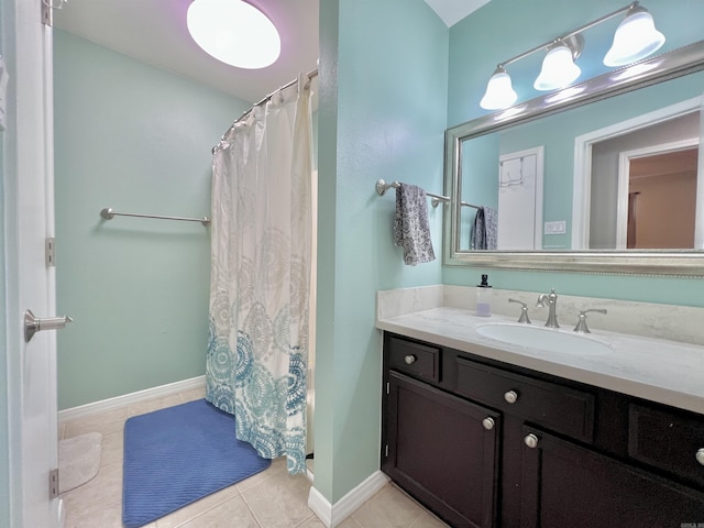 bathroom featuring vanity, baseboards, and tile patterned floors