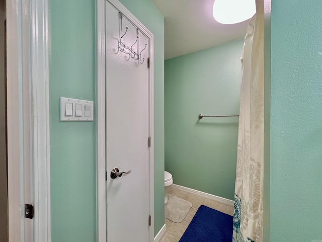 full bath featuring toilet, baseboards, and tile patterned floors