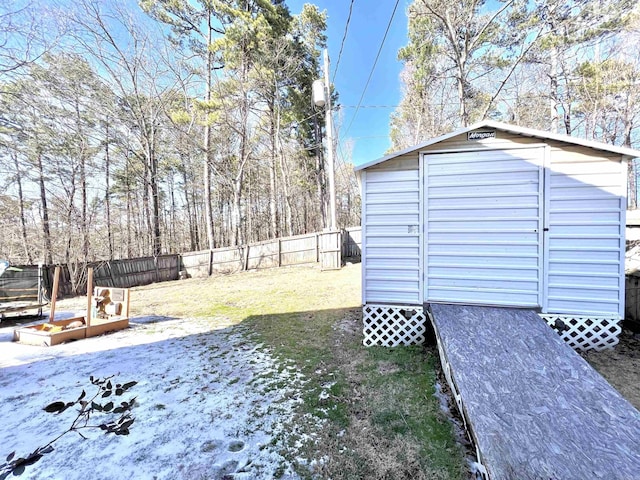 view of yard with a fenced backyard, a storage unit, and an outbuilding