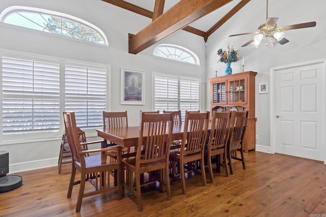 dining space with baseboards, high vaulted ceiling, wood finished floors, and beamed ceiling