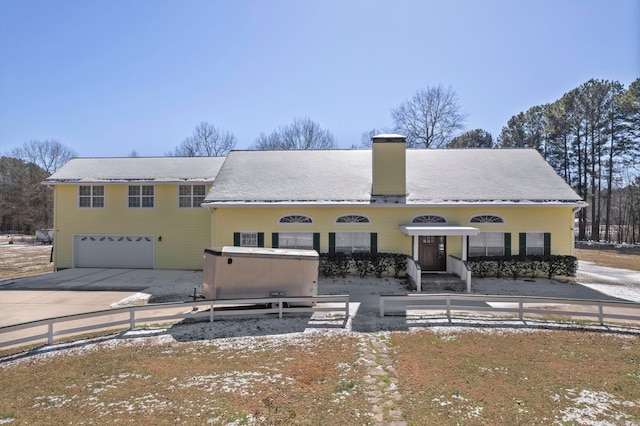 view of front of house featuring a garage, concrete driveway, and a chimney