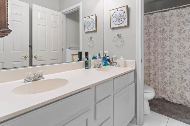 bathroom with tile patterned flooring, a sink, toilet, and double vanity