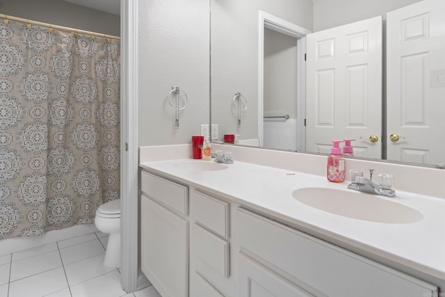 bathroom with toilet, tile patterned flooring, double vanity, and a sink