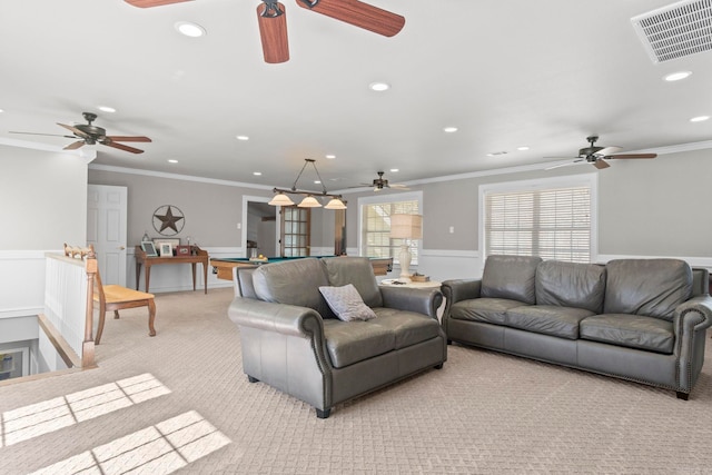 living area featuring ornamental molding, light colored carpet, a wainscoted wall, and visible vents