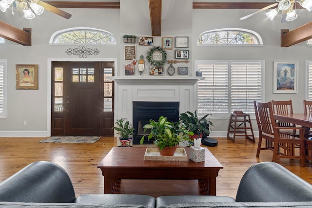 living area featuring light wood-type flooring, a wealth of natural light, and a ceiling fan