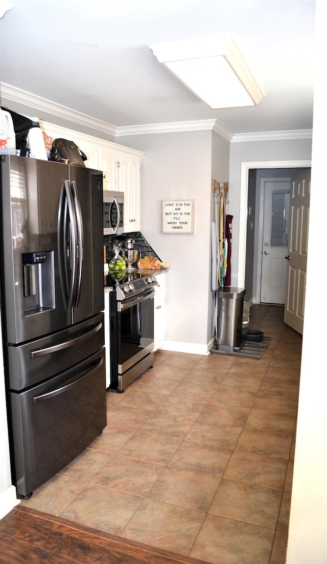 kitchen with stainless steel appliances, baseboards, white cabinets, ornamental molding, and tasteful backsplash