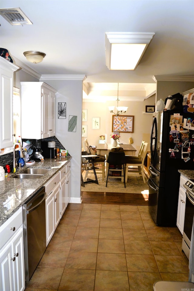 kitchen with visible vents, appliances with stainless steel finishes, white cabinets, and decorative light fixtures