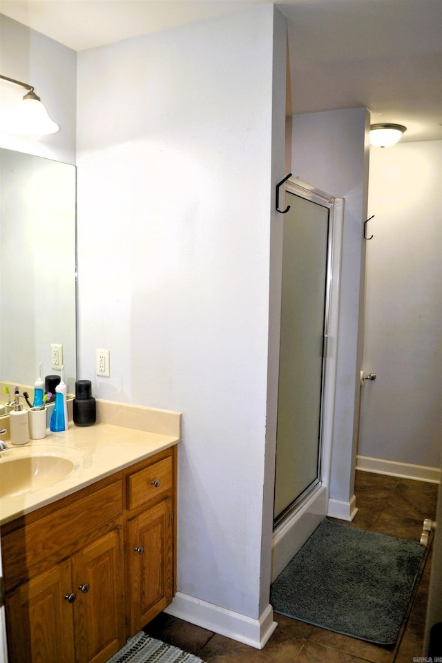 full bath featuring baseboards, vanity, a shower stall, and tile patterned floors