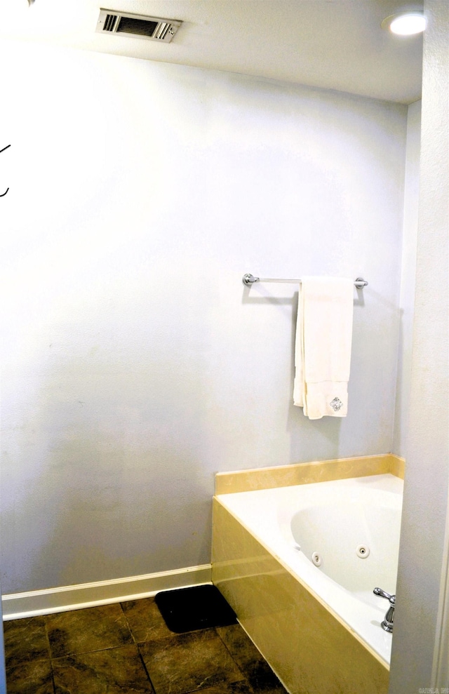 full bathroom featuring baseboards, visible vents, a tub with jets, and tile patterned floors