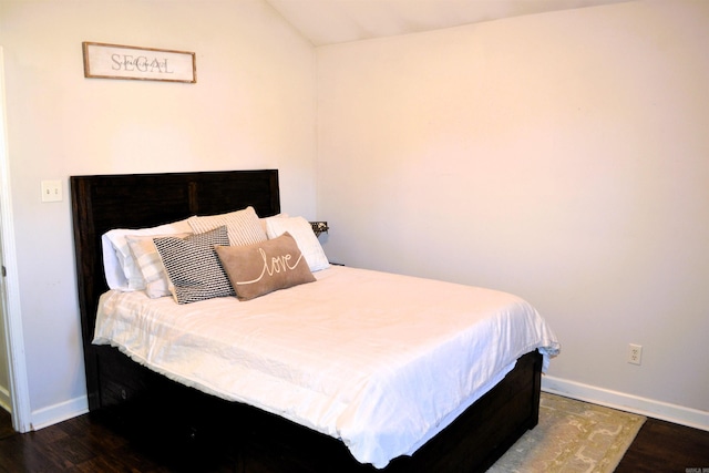 bedroom with lofted ceiling, baseboards, and dark wood-style flooring