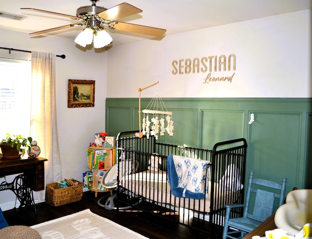 bedroom featuring a notable chandelier, a wainscoted wall, a decorative wall, dark wood-type flooring, and visible vents