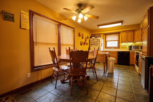 dining space with visible vents, ceiling fan, baseboards, and stone tile floors