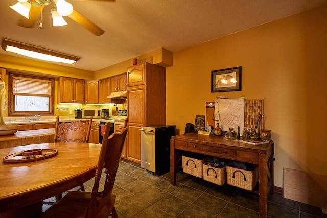 dining room featuring dark tile patterned floors and ceiling fan