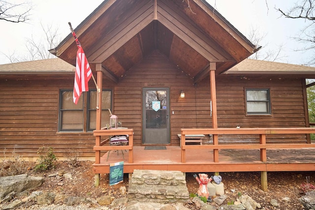 doorway to property featuring a shingled roof