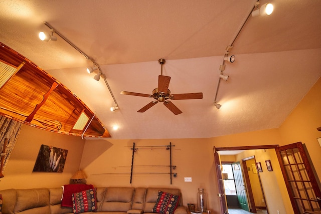 living room with a ceiling fan, lofted ceiling, and track lighting