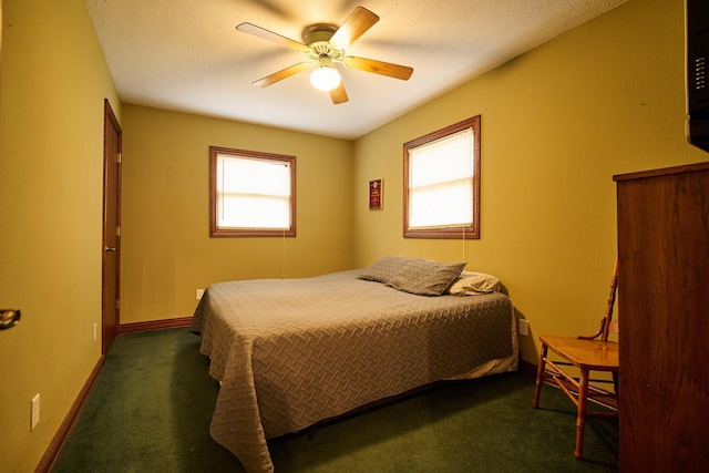 bedroom featuring ceiling fan, dark colored carpet, and baseboards