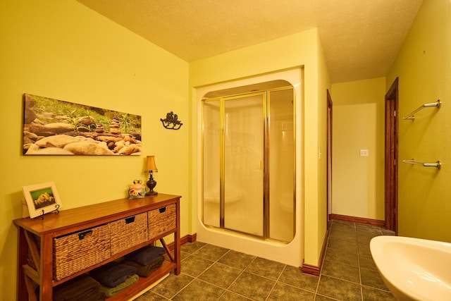 full bath featuring a textured ceiling, a stall shower, and tile patterned flooring