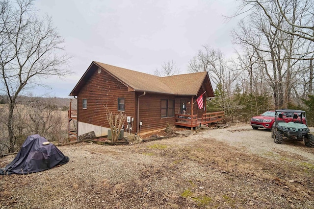 view of side of home with driveway and a wooden deck