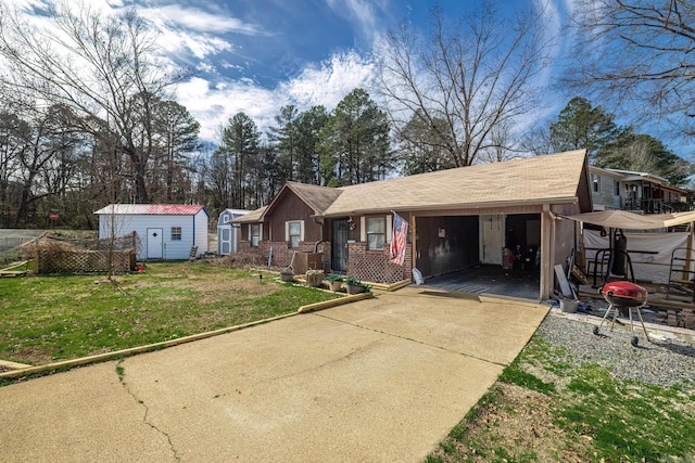 view of front of property with concrete driveway, brick siding, a front yard, and an outdoor structure