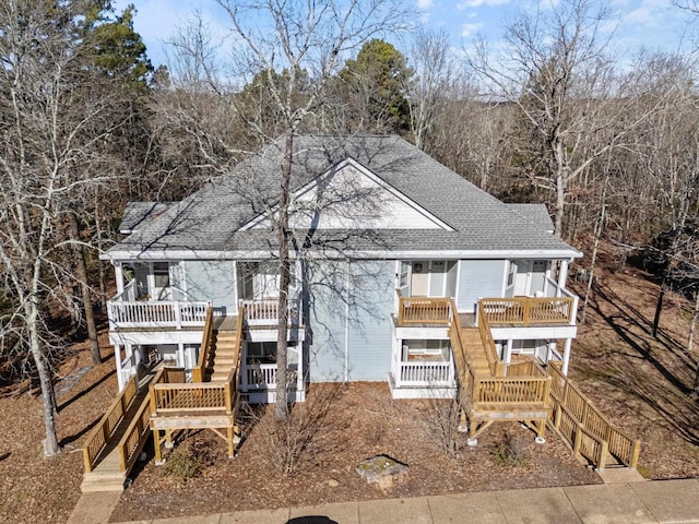 view of front of property featuring stairs, a porch, and roof with shingles