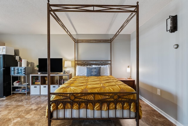 bedroom featuring a textured ceiling and baseboards