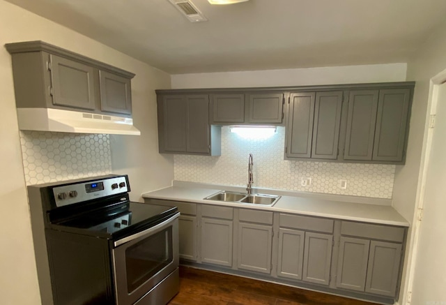 kitchen featuring under cabinet range hood, electric range, light countertops, and a sink