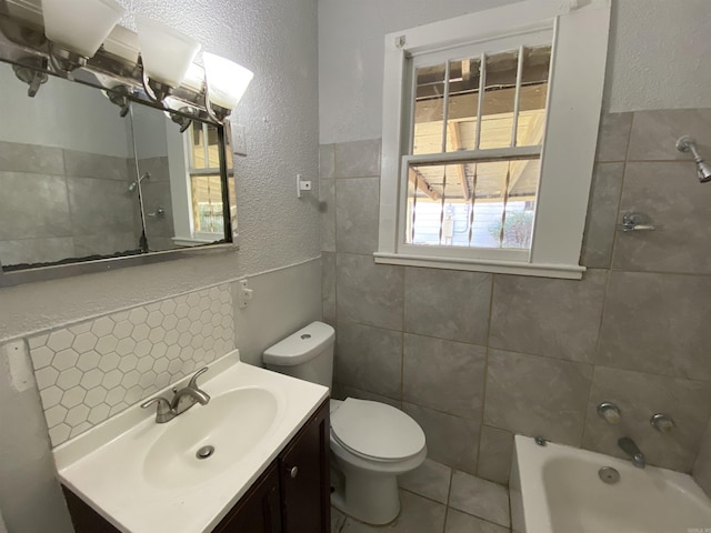 full bath with toilet, a textured wall, tile walls, and vanity