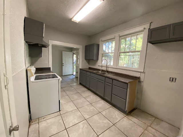 kitchen featuring dark countertops, electric range, gray cabinetry, a sink, and a textured ceiling