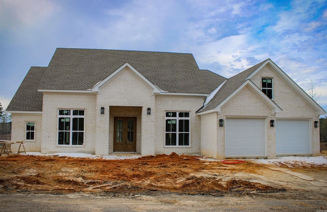 view of front of home with brick siding and roof with shingles