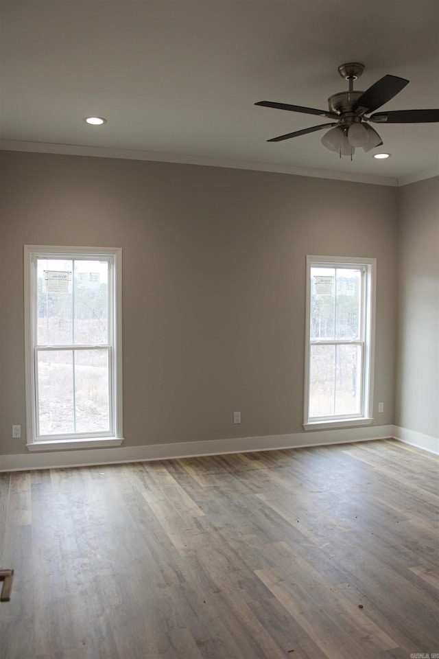 spare room with baseboards, light wood finished floors, recessed lighting, and crown molding