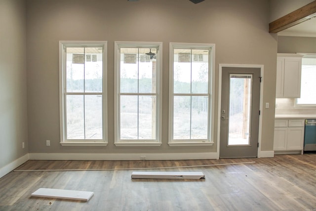 doorway featuring light wood finished floors and baseboards