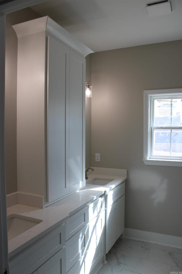 bathroom with marble finish floor, baseboards, and vanity