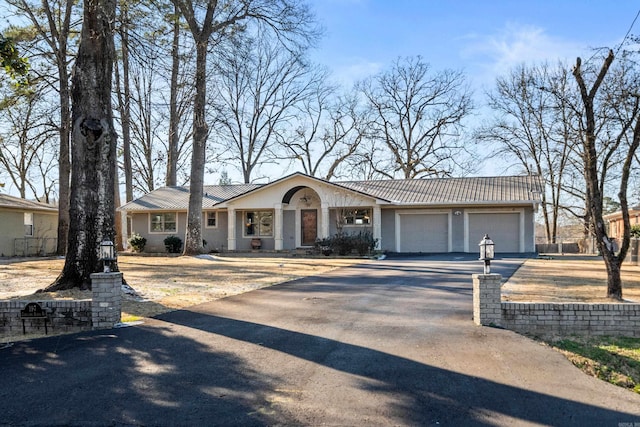 view of front of home with metal roof, driveway, and an attached garage