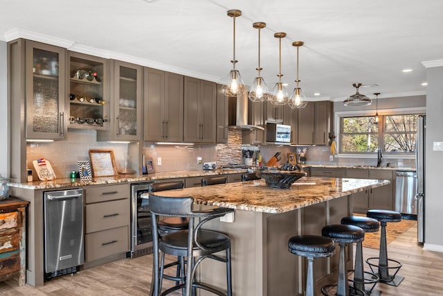 kitchen featuring a kitchen island, glass insert cabinets, a breakfast bar, decorative light fixtures, and stainless steel appliances