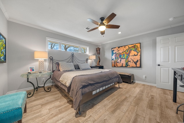 bedroom featuring baseboards, ornamental molding, visible vents, and light wood-style floors