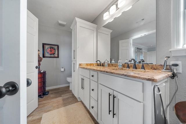 full bathroom featuring visible vents, a sink, toilet, and wood finished floors