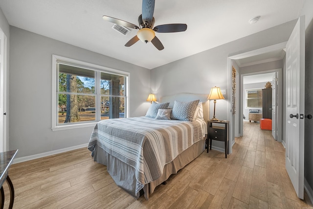 bedroom with a ceiling fan, light wood-type flooring, visible vents, and baseboards