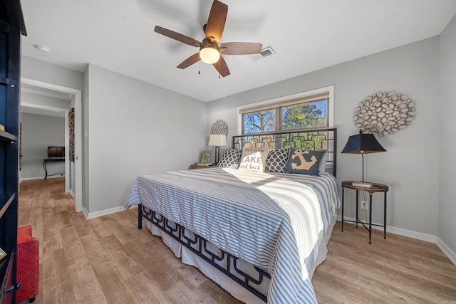 bedroom with wood finished floors, visible vents, and baseboards