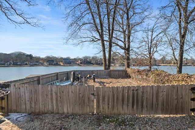 view of dock with a water view and fence