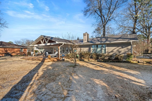 back of house with a patio area, fence, a chimney, and brick siding