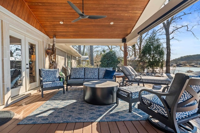 wooden deck featuring a water view, ceiling fan, outdoor lounge area, and french doors