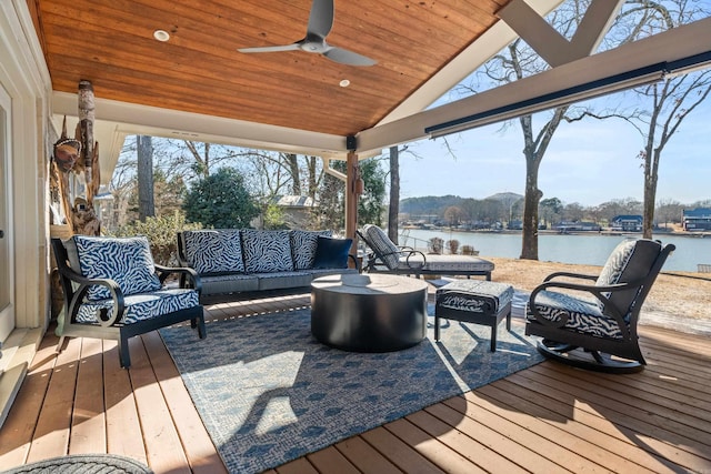 wooden terrace with a water view, ceiling fan, and an outdoor hangout area